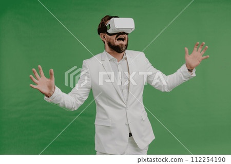 Businessman wearing white VR glasses on green background 112254190