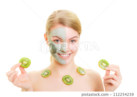 Skin care. Woman in clay mask on face and kiwi Skin care. Woman in clay mask on face and kiwi 112254239