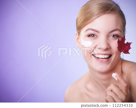 Skin care. Face of young woman girl with red maple leaf. Skin care. Face of young woman girl with red maple leaf. 112254310