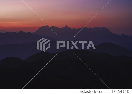 nature traveling with orange sky and layer of mountain with sunrise background 112254948