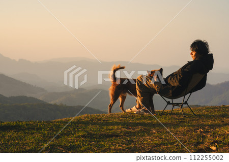 nature traveling with solo man play with dog and see sunrise with layer of mountain nature traveling with solo man play with dog and see sunrise with layer of mountain 112255002
