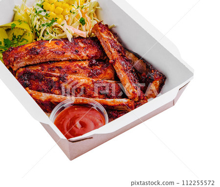 Tasty grilled ribs with vegetables in box 112255572