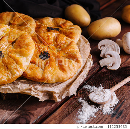 Cooking traditional pies with potato on wooden board Cooking traditional pies with potato on wooden board 112255683