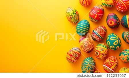 A row of colorful pastel Easter eggs, each uniquely painted with different texture on a yellow background 112255937