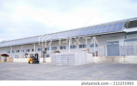 Forklift and pallets with goods in large warehouse outside warehouse 112255993