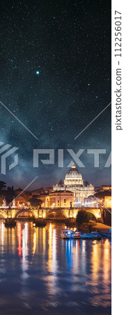 Rome, Italy. starry night stars sky above Papal Basilica Of St. Peter In The Vatican And Aelian Bridge In Evening Night Illuminations. Vertical panorama 112256017