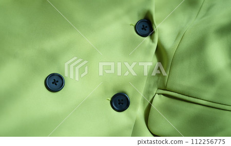 Closeup of custom made green jacket with black buttons 112256775