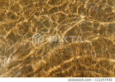 beige sand contrasts with the ocean, making it a work of art in nature. concept for perfumes, smells, heat, freshness, coolness and other associations. Ripple sea ocean water surface with small waves 112257440