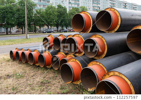 Steel pipe with heat insulation. New black insulated steel pipes at municipal construction site outdoors. Heating main district pipeline renewal or reconstruction. Steel pipe with heat insulation. New black insulated steel pipes at municipal construction site outdoors. Heating main district pipeline renewal or reconstruction. 112257597