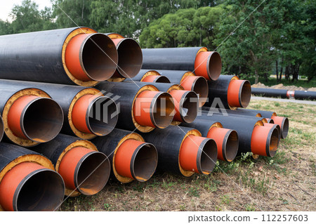 Steel pipe with heat insulation. New black insulated steel pipes at municipal construction site outdoors. Heating main district pipeline renewal or reconstruction. Steel pipe with heat insulation. New black insulated steel pipes at municipal construction site outdoors. Heating main district pipeline renewal or reconstruction. 112257603