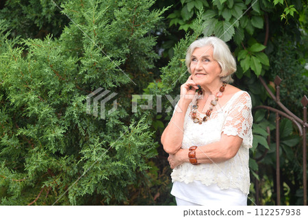 Portrait of happy senior woman posing at forest 112257938