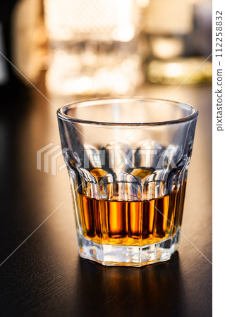 Whiskey in a glass tumbler warm backlight 112258832