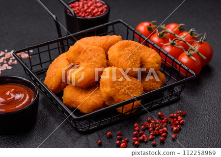 Delicious fresh crispy chicken nuggets on a dark concrete background Delicious fresh crispy chicken nuggets on a dark concrete background 112258969