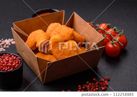 Delicious fresh crispy chicken nuggets on a dark concrete background 112258985