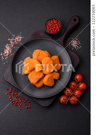 Delicious fresh crispy chicken nuggets on a dark concrete background 112259065