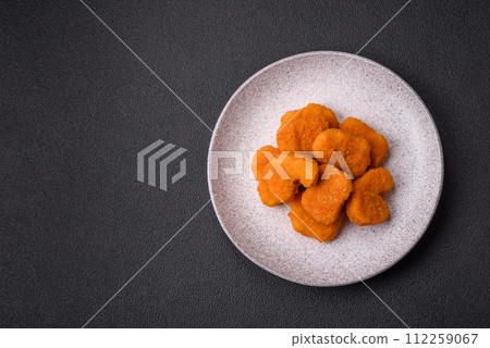 Delicious fresh crispy chicken nuggets on a dark concrete background 112259067