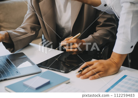 Business team working with new startup project plan and discussion information for financial strategy with laptop and digital tablet in a modern business lounge. 112259483