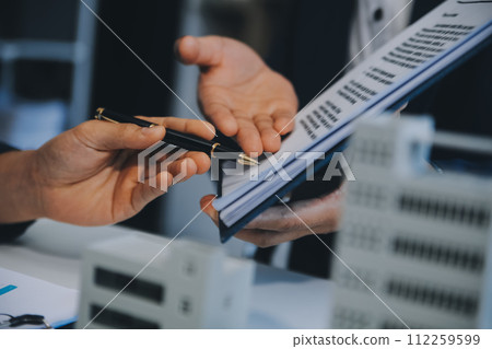 Real estate agent talked about the terms of the home purchase agreement and asked the customer to sign the documents to make the contract legally, Home sales and home insurance concept. 112259599