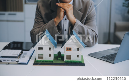 Real estate agent talked about the terms of the home purchase agreement and asked the customer to sign the documents to make the contract legally, Home sales and home insurance concept. 112259610