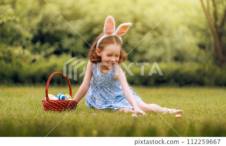 child with painting eggs outdoors 112259667