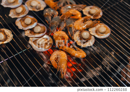 Scallops and shrimp grilled over charcoal grill Scallops and shrimp grilled over charcoal grill 112260288