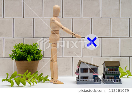 A mannequin with a cross and a detached house 112261079