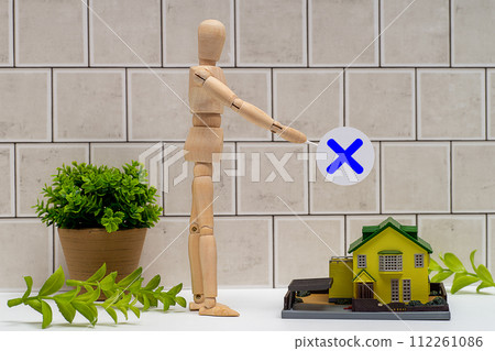 A mannequin with a cross and a detached house A mannequin with a cross and a detached house 112261086