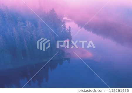 Fir trees around the lake in autumn. Lake Synevyr in the Carpathian Mountains of Ukraine. Synevyr Poliana National Park  in Zakarpattia Oblast. Ukraine 112261326
