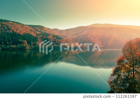 Mountain lake in autumn. Colorful autumn forest around the lake. Synevyr Poliana National Park in Zakarpattia Oblast, Ukraine Mountain lake in autumn. Colorful autumn forest around the lake. Synevyr Poliana National Park in Zakarpattia Oblast, Ukraine 112261397