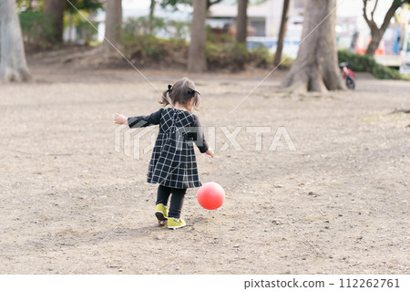 A little girl playing with a ball A little girl playing with a ball 112262761
