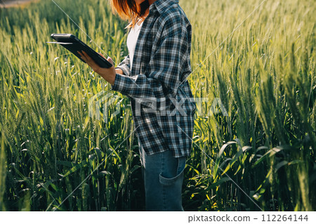 Smart farm. Farmer with tablet in the field. Agriculture, gardening or ecology concept. Harvesting. Agro business. 112264144
