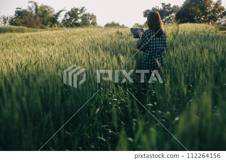 Smart farm. Farmer with tablet in the field. Agriculture, gardening or ecology concept. Harvesting. Agro business. 112264156
