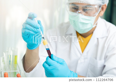 Researcher or scientists loads liquid into blood sample in test tube. Researchers are developing vaccines and medicine to treat the COVID-19 virus. 112264706