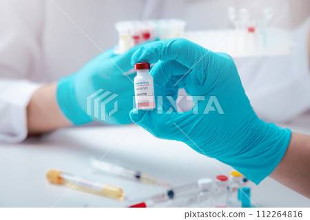 Researcher holding vaccine sample in the laboratory. Researcher is inventing vaccines to treat COVID-19 virus. 112264816