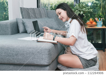 Young student watching lesson online and studying from home. She using laptop and learning online.  Distance learning online education. 112264906