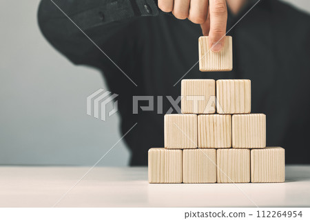 Hand putting and stacking blank wooden cubes on table with copy space for input wording or infographic icon 112264954