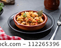Ropa vieja, typical Canarian dish of chickpeas stew with chicken and potatoes in a earthenware casserole. 112265396