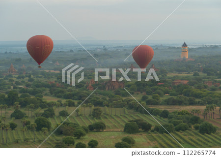 Balloons flying over Burmese temples of Bagan City from a balloon, unesco world heritage with forest trees, Myanmar or Burma. Tourist destination. 112265774