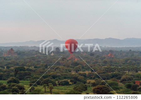 Balloons flying over Burmese temples of Bagan City from a balloon, unesco world heritage with forest trees, Myanmar or Burma. Tourist destination. 112265806
