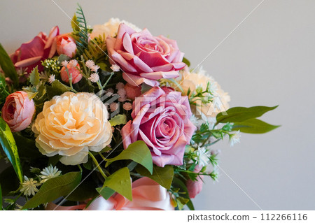 top view pinks and yellow rose flowers bouquet on white cement wall background, nature, template, decor, copy space 112266116