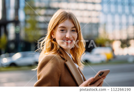 Portrait beautiful realtor strolling street and looking camera with smile Portrait beautiful realtor strolling street and looking camera with smile 112266190