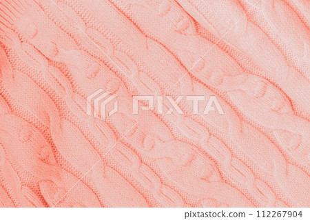 Knitted texture, Coral color with pattern, woolen knit fabric closeup. Background 112267904