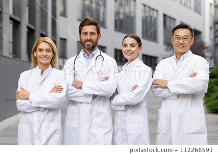 Professional male and female doctors in lab coats standing confidently outside a hospital, evoking trust and expertise. Professional male and female doctors in lab coats standing confidently outside a hospital, evoking trust and expertise. 112268591
