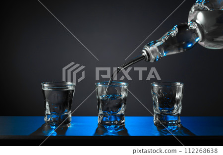 Barman pouring hard spirit into glasses. Barman pouring hard spirit into glasses. 112268638