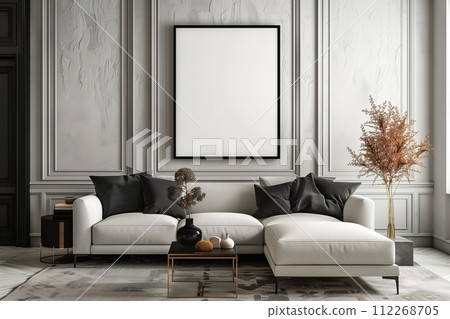 A white couch with black pillows sits in front of a large white framed picture 112268705