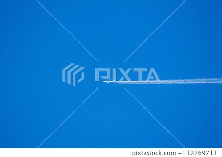 An airplane cloud extending into the blue sky 112269711