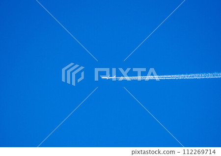 An airplane cloud extending into the blue sky 112269714