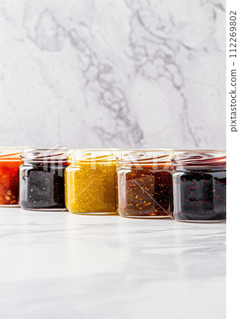 AI-generated content. Jams jars of different flavors and colors in a row on marble table with marble gray background. High quality photo 112269802
