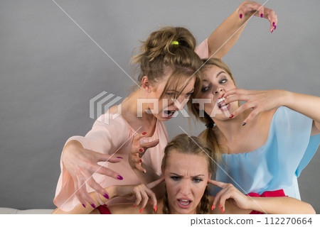 Woman being bullied by two females Woman being bullied by two females 112270664
