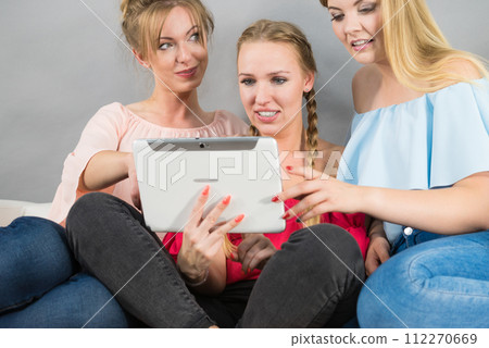 Three women using tablet Three women using tablet 112270669